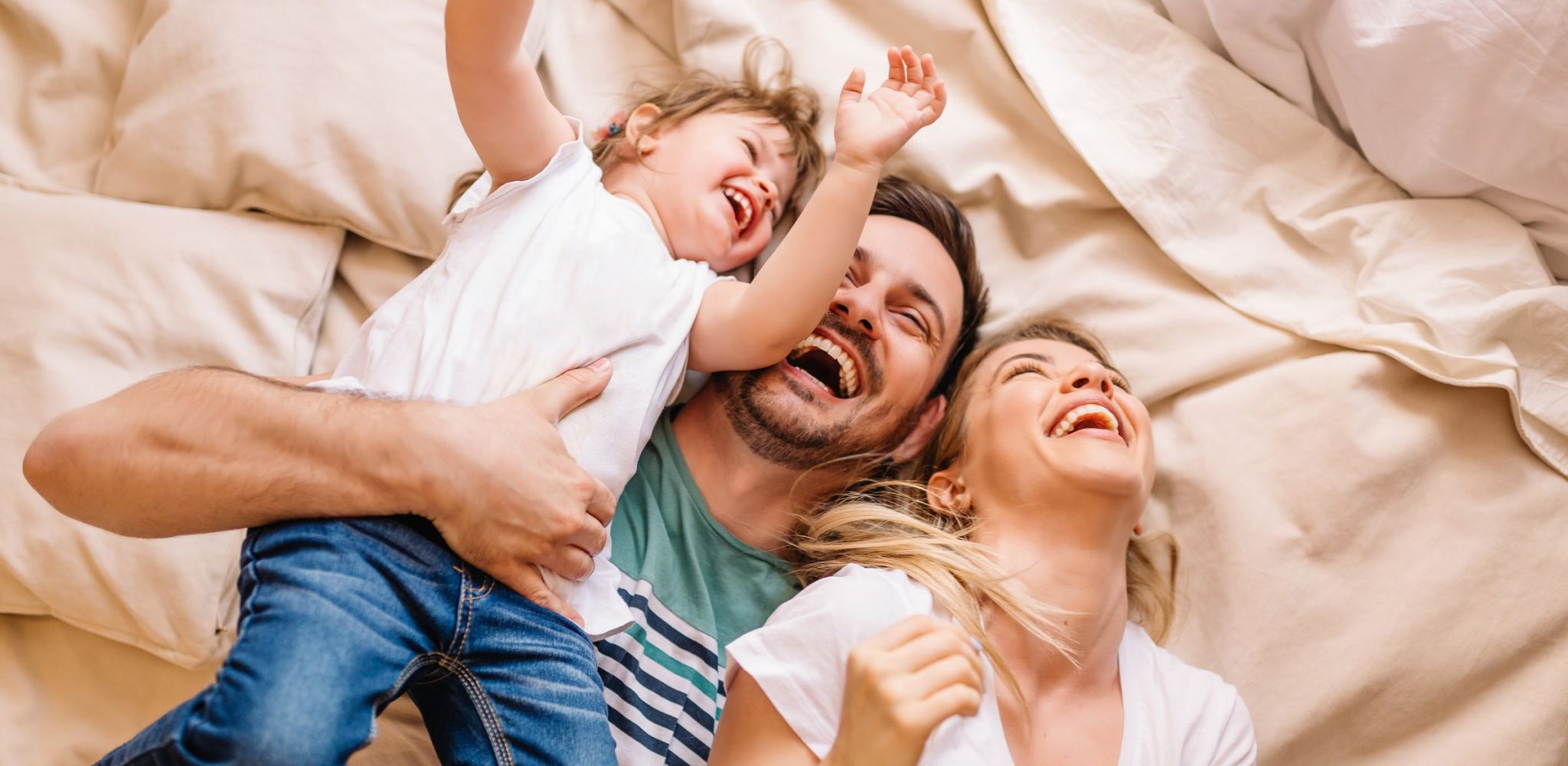Encore at Reems Creek family laying in bed laughing together