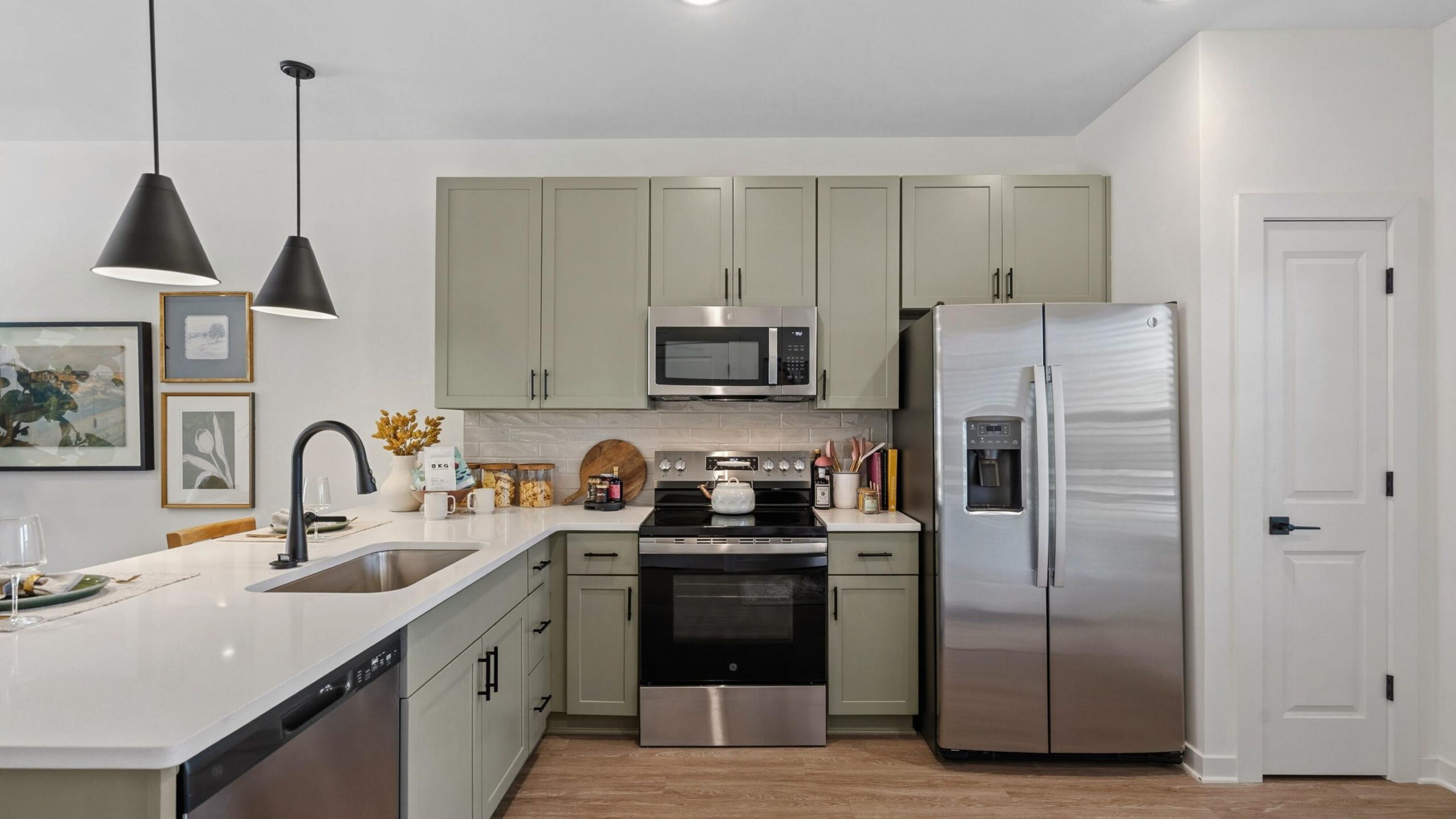 Encore at Reems Creek apartment kitchen area with wrap around kitchen island, stainless steel appliances, and ample cabinet storage