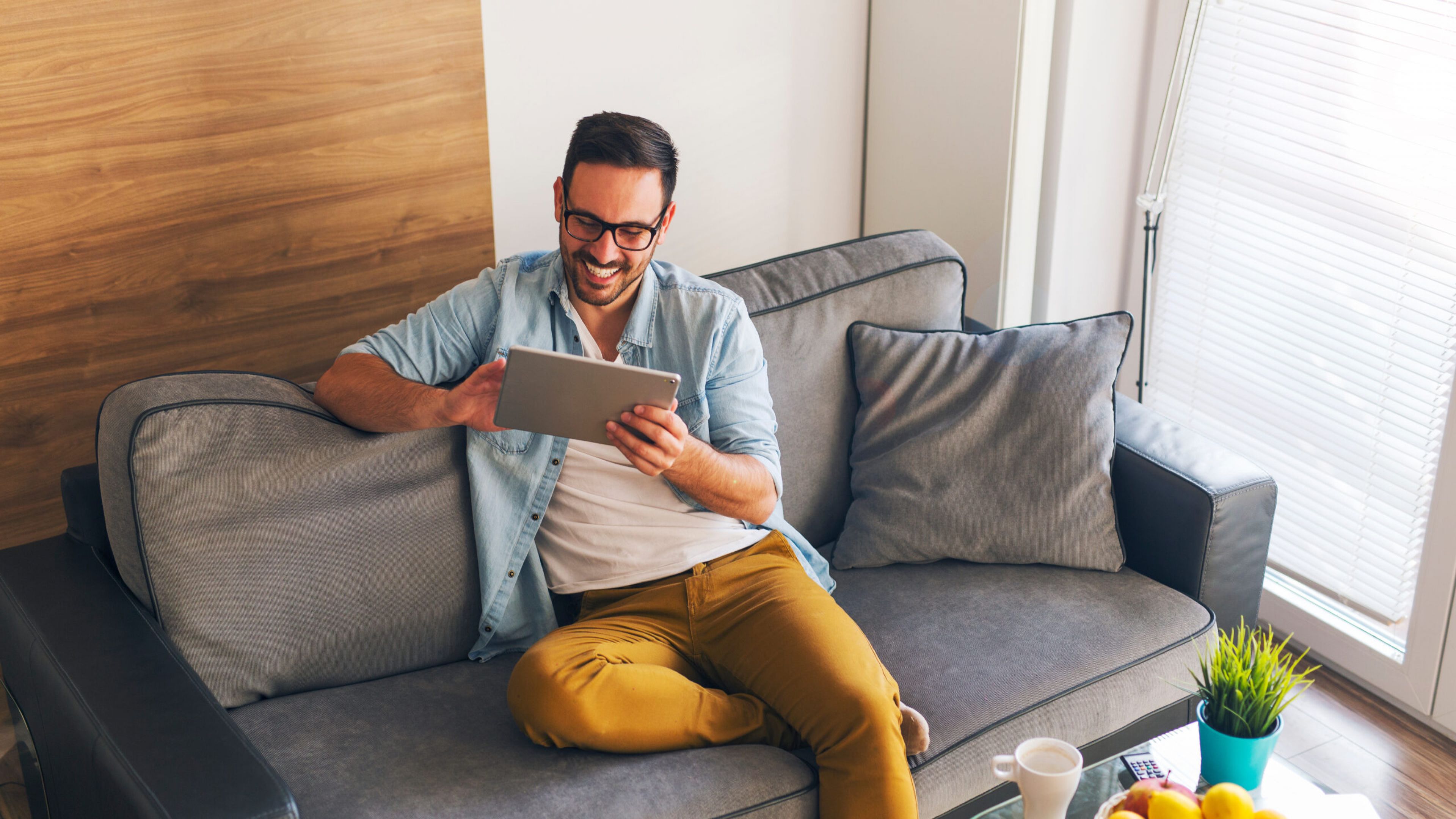 Encore at Reems Creek smiling young man relaxing at home and using tablet